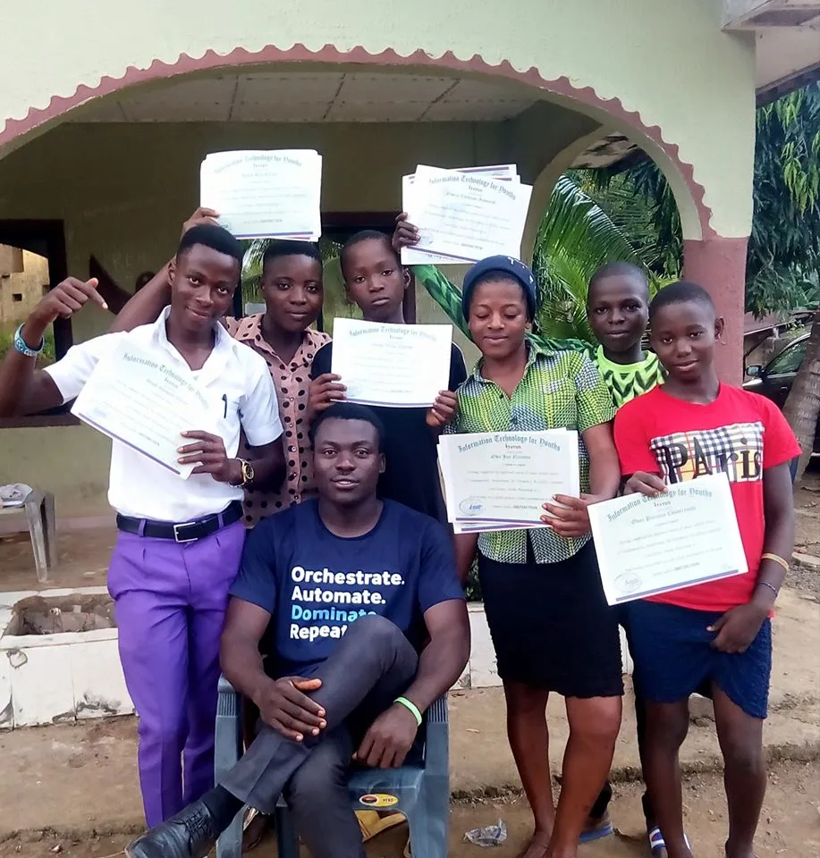 Students with certificates gather around a seated trainer
