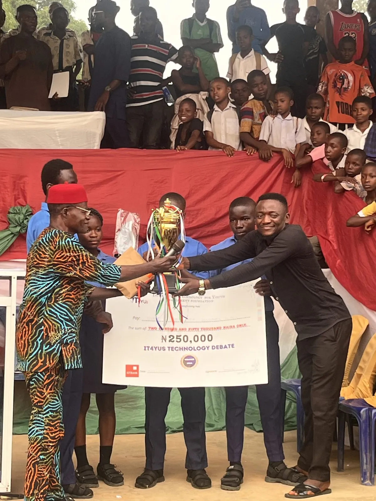The Community Secondary School team receive the trophy and cheque at the 2026 IT4YUS Technology Debate