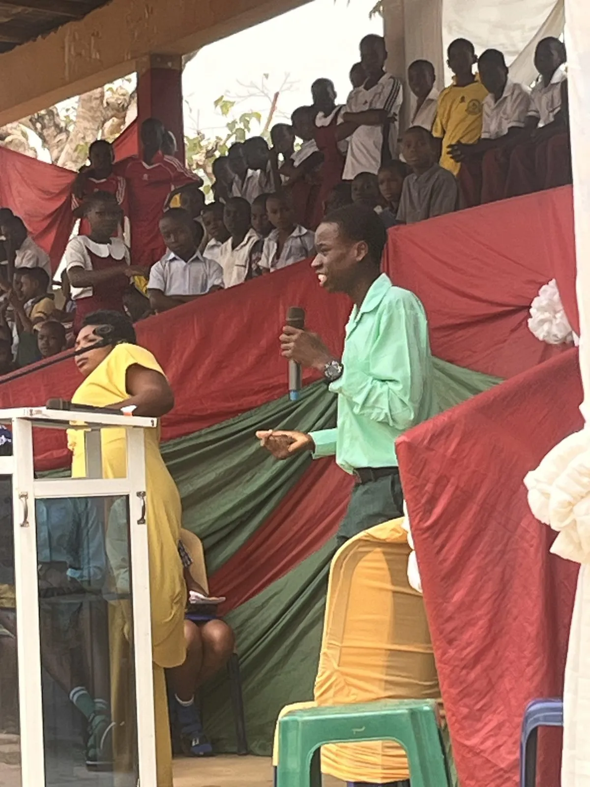 A student in a green shirt argues his case at the microphone, 2026