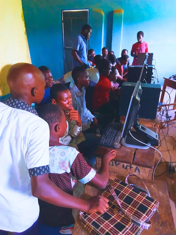 A trainer helps students at desktop computers in the IT4YUS centre