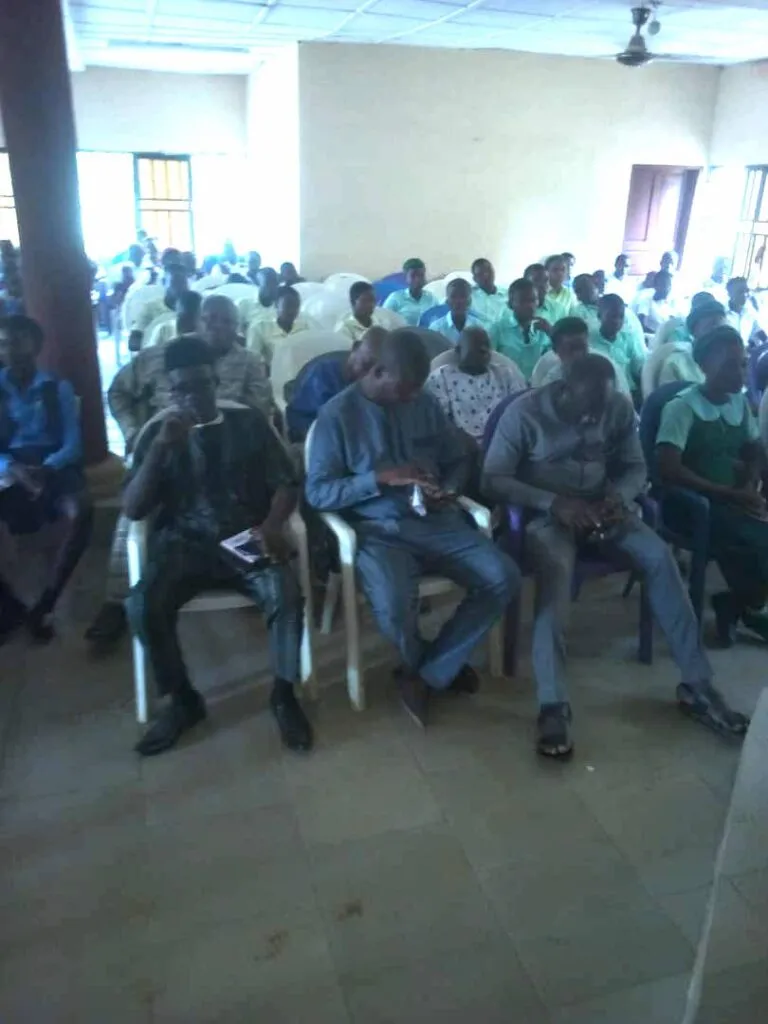Teachers, guests and students seated in the hall