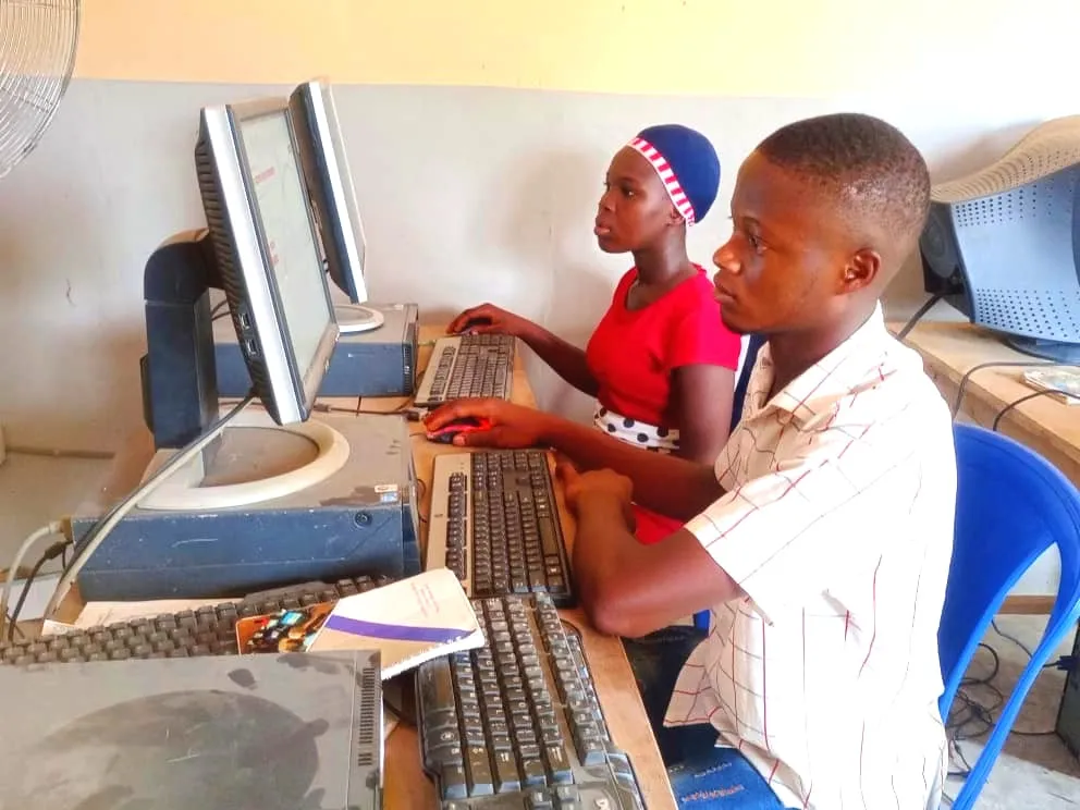 A young woman and young man focus on their screens during a bootcamp session