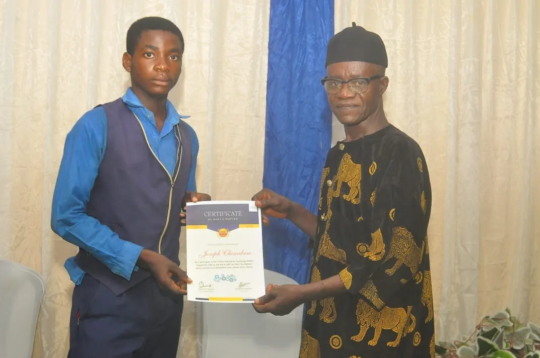 A student in a waistcoat receives his certificate