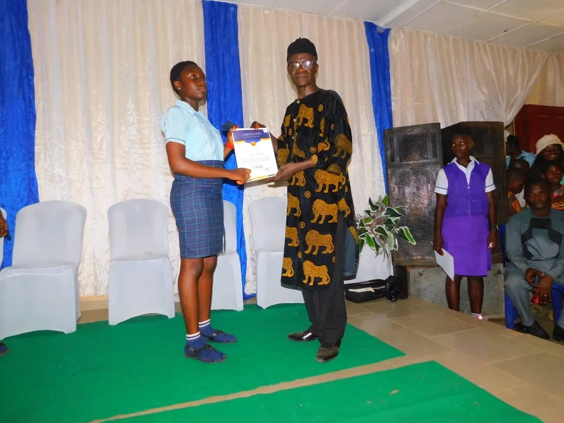 A student smiles as she receives her certificate