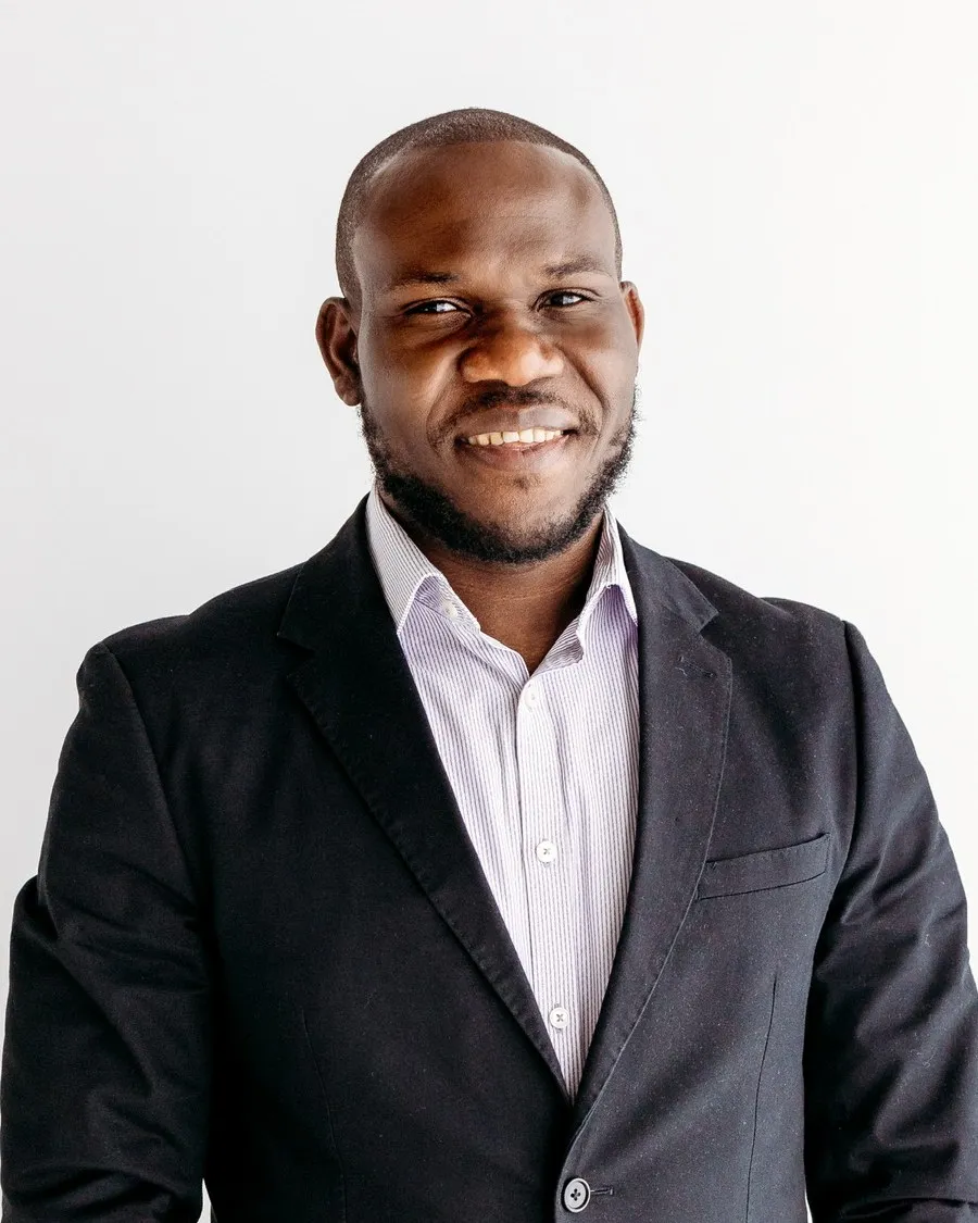 Kelechi Okpara, founder of IT4YUS, smiling in a dark blazer