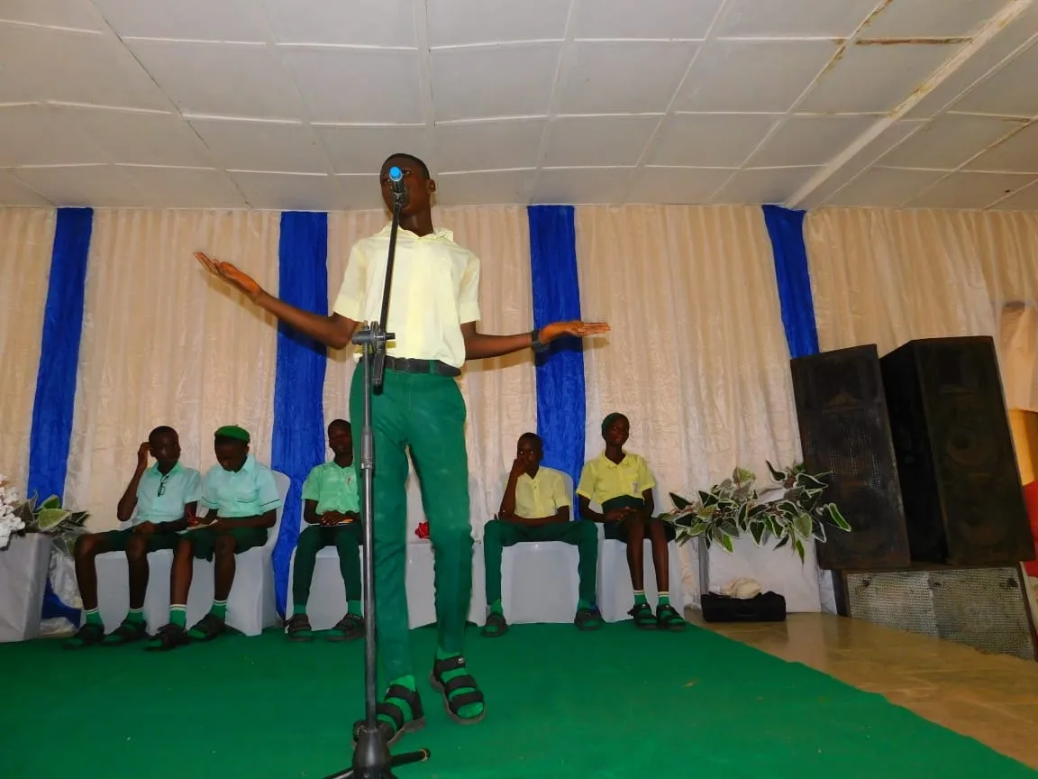 A student speaks with arms wide on stage