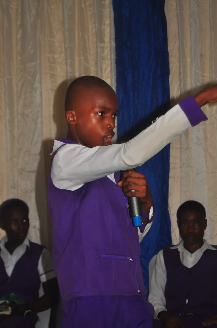 A student speaks at the microphone, pointing to make his point